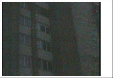 Naktinė renovuoto daugiabučio nuotrauka Žaliųjų ežerų g. 3, matomi langai ir siluetiniai kontūrai.