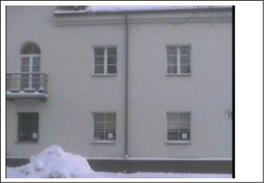 Renovuoto plytų mūro gyvenamojo namo nuotrauka žiemą, su matomu balkonu ir langais, kurie atitinka termovizijoje pažymėtus taškus.